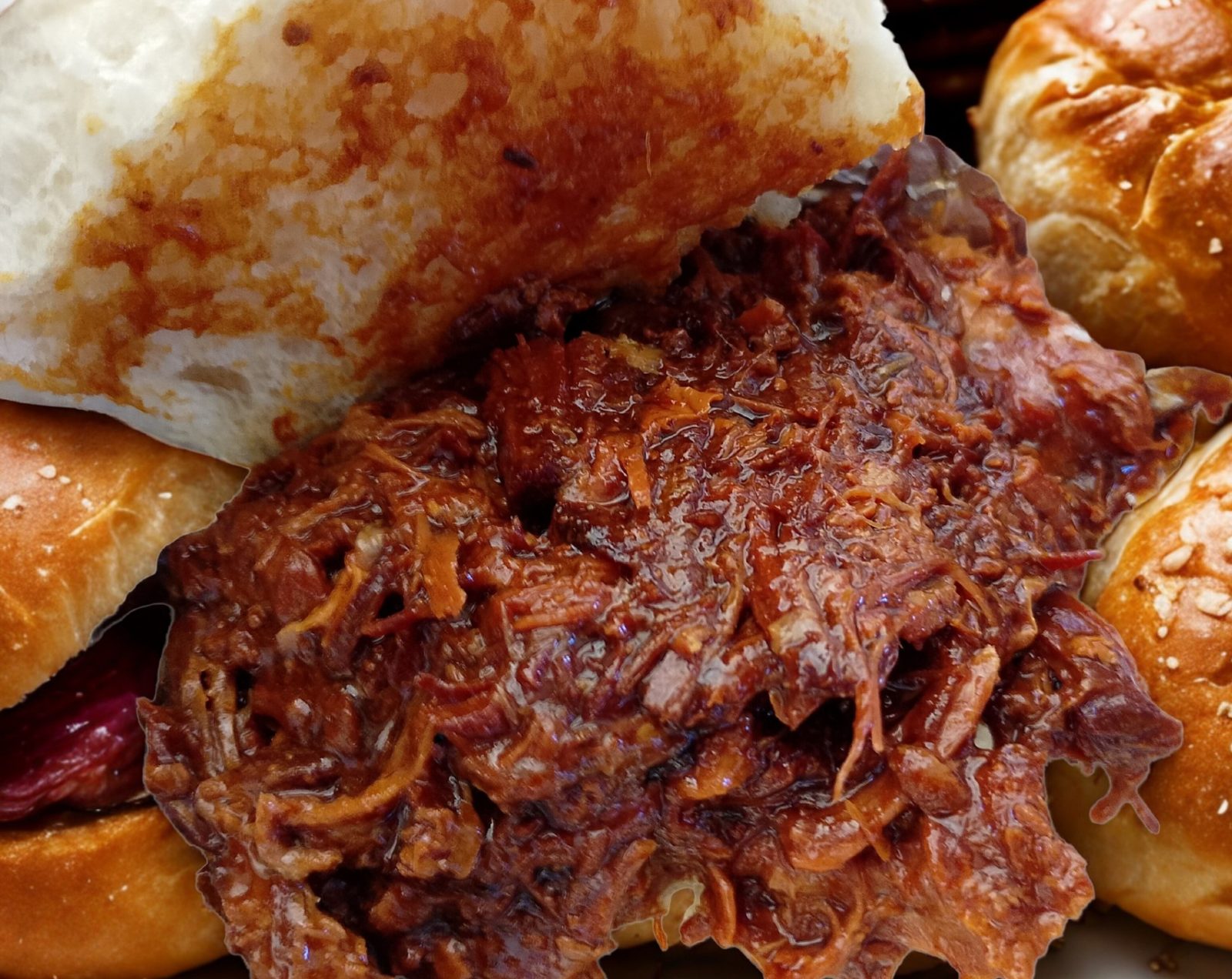 Smoked pulled meat piled into a soft roll