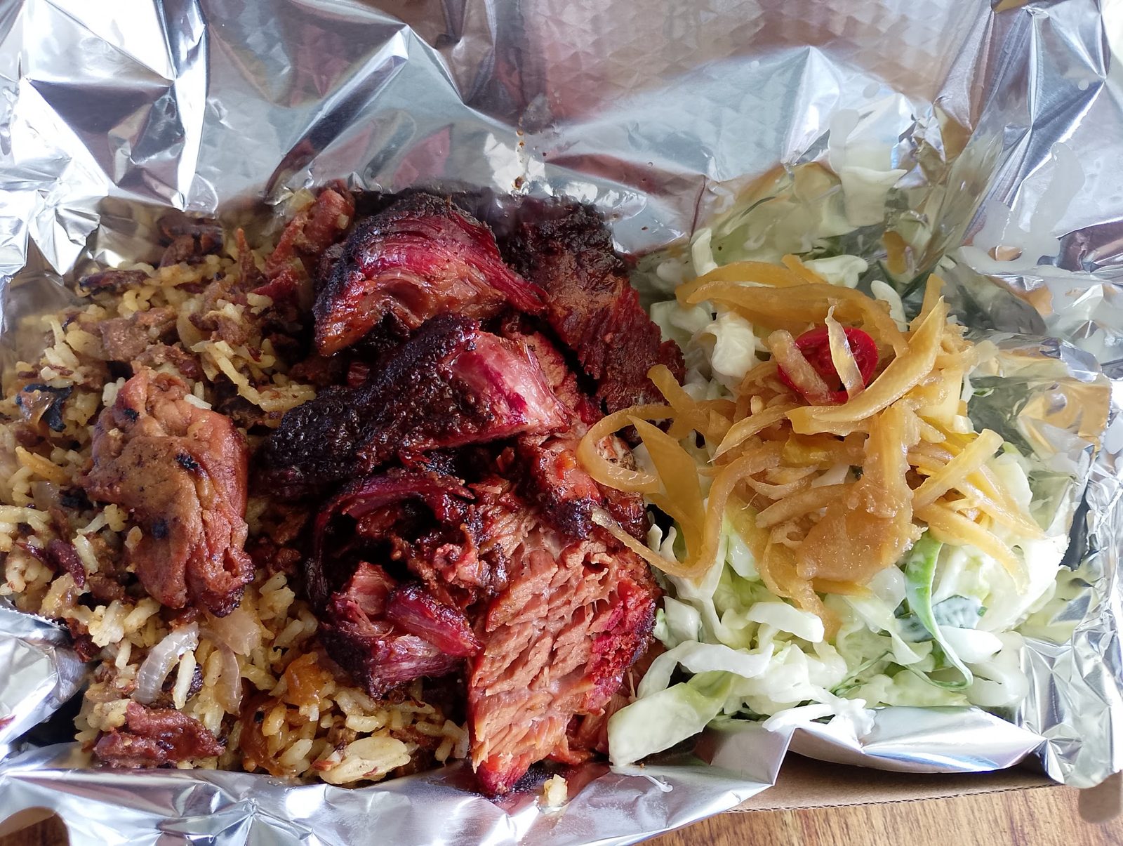 Takeaway tray of sliced brisket, rice and coleslaw